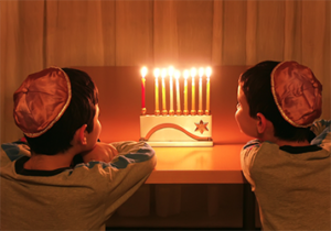 2 boys looking at a menorah