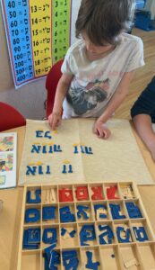 student doing puzzles with Hebrew letters